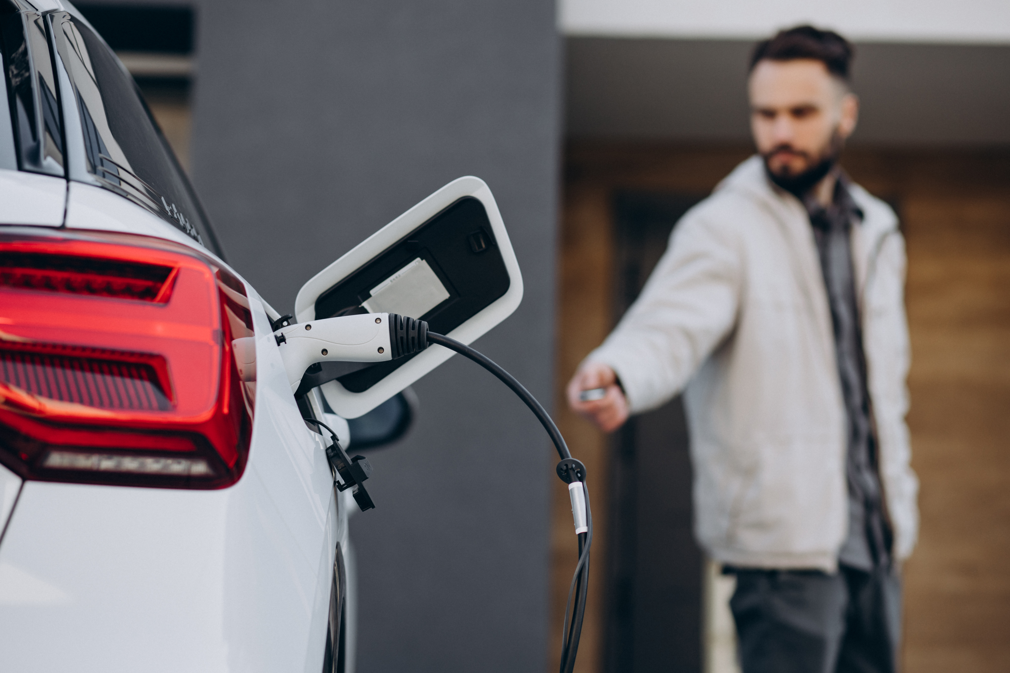 Homem carregando carro elétrico em casa